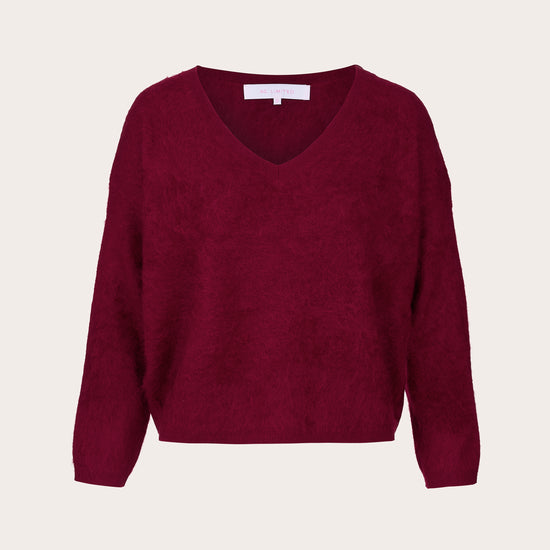 A textured knit V-neck sweater in deep burgundy, displayed flat against a light cream background.