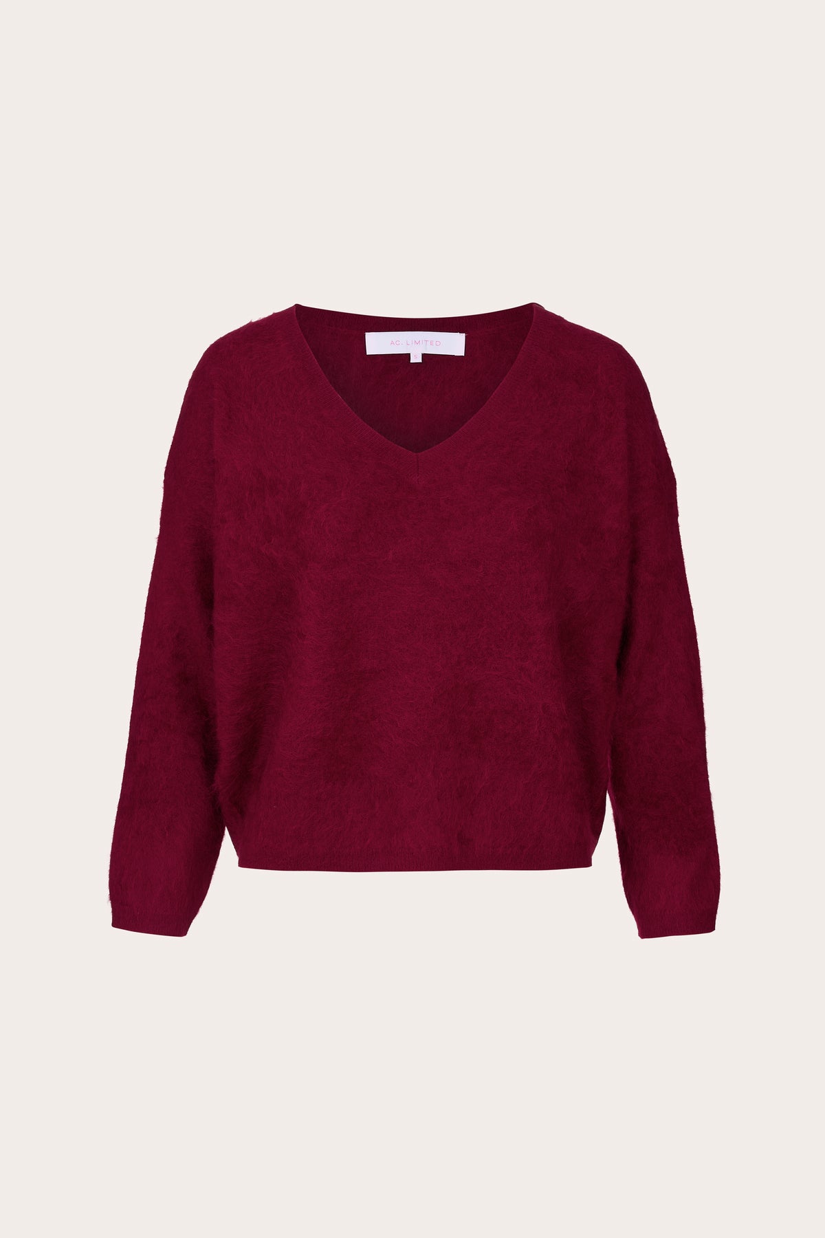 A textured knit V-neck sweater in deep burgundy, displayed flat against a light cream background.