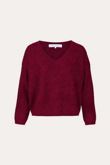A textured knit V-neck sweater in deep burgundy, displayed flat against a light cream background.