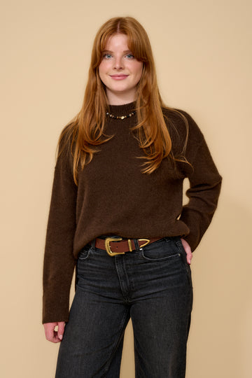 model shot wearing brown jumper black jeans and brown belt with a gold buckle