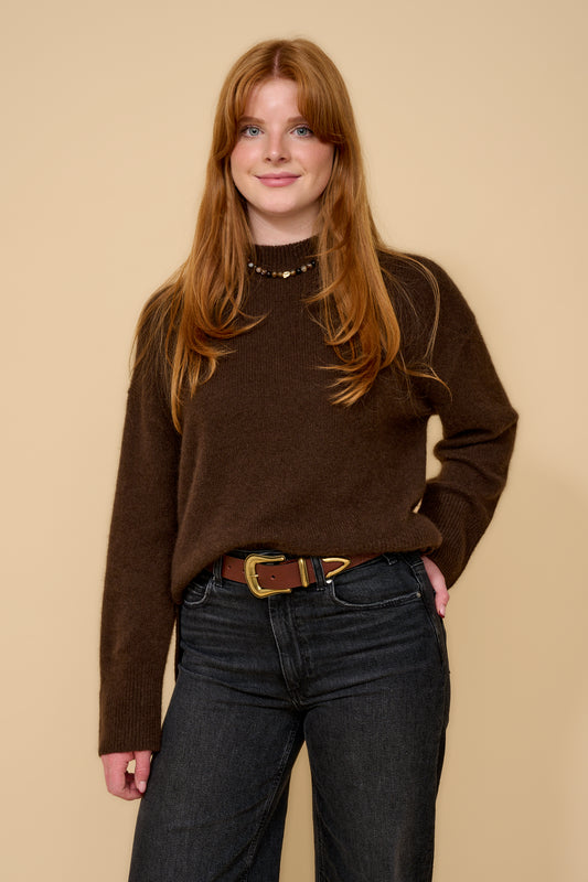model shot wearing brown jumper black jeans and brown belt with a gold buckle