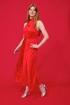 model shot wearing a red halterneck dress with open back and a tie and mid length from samsoe samsoe and silver heels with a red background