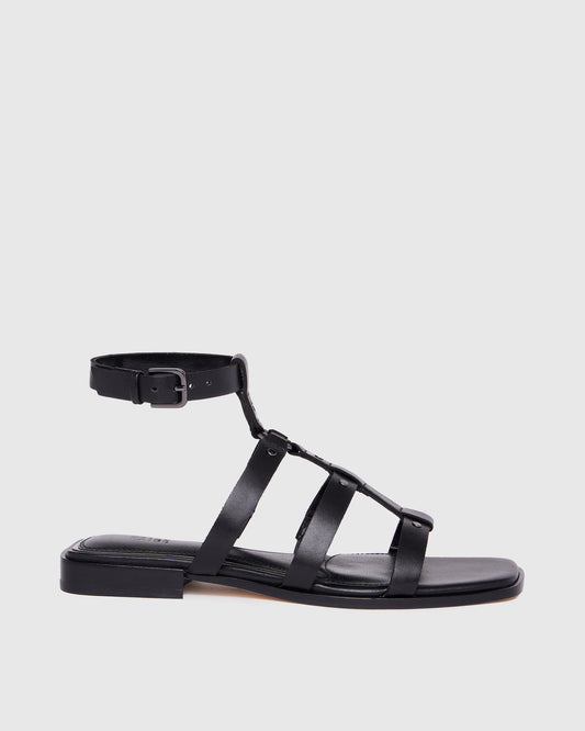 Black sandal with multiple straps on a light gray background