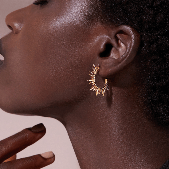 medium sized gold hoops with varying sized spike detailing along the edging and butterfly fastening from rachel jackson model shot