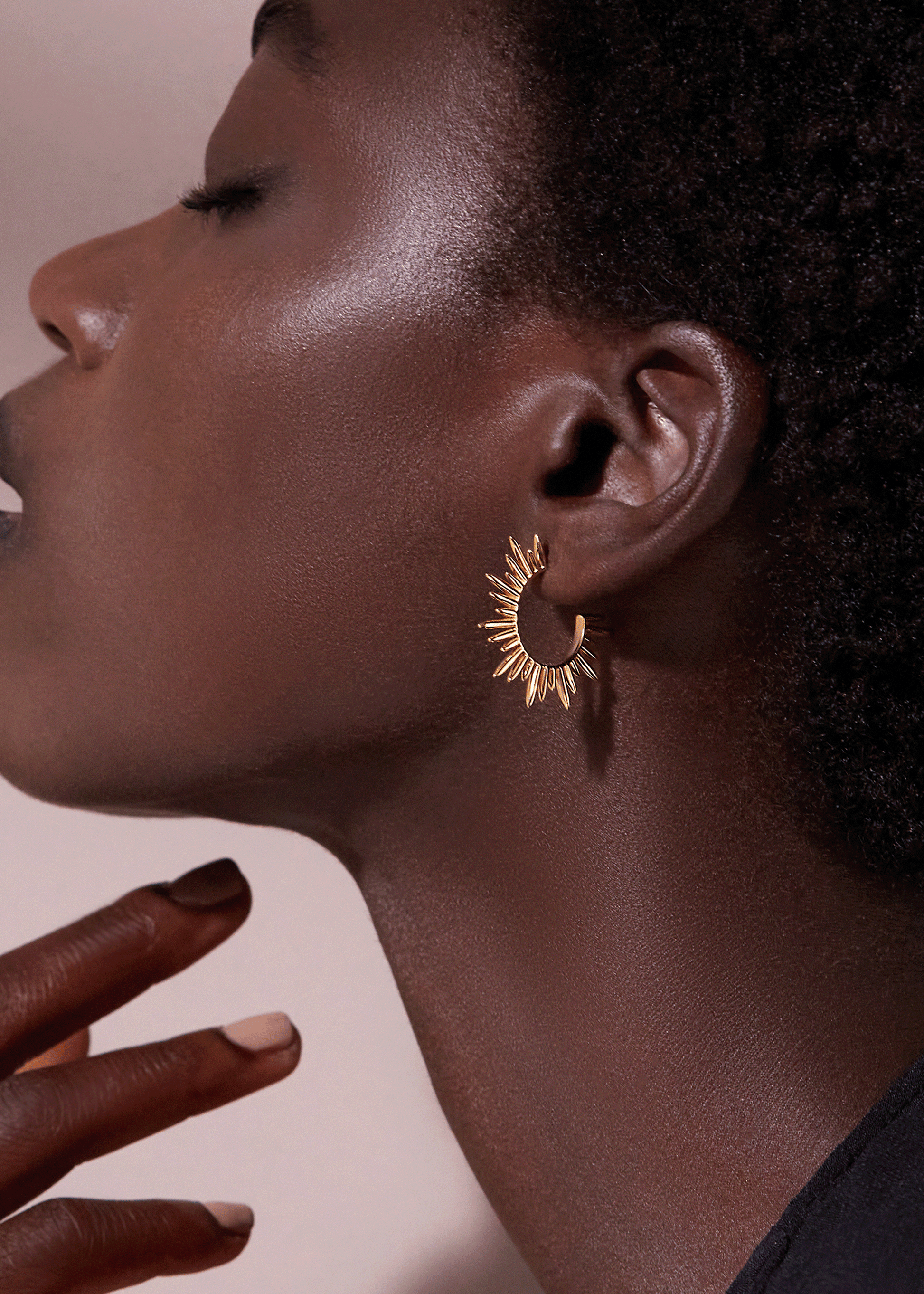medium sized gold hoops with varying sized spike detailing along the edging and butterfly fastening from rachel jackson model shot