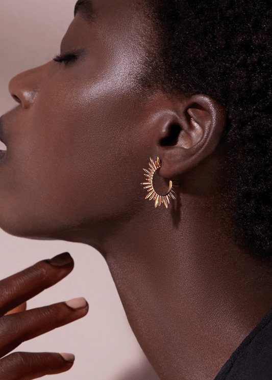 medium sized gold hoops with varying sized spike detailing along the edging and butterfly fastening from rachel jackson model shot