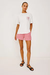 White tee with Sardines decal worn with red gingham shorts from rails