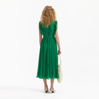 Emerald green sleeveless dress with pintuck bodice ruffle over the shoulder and midi length skirt with delicate pleats with fabric belt