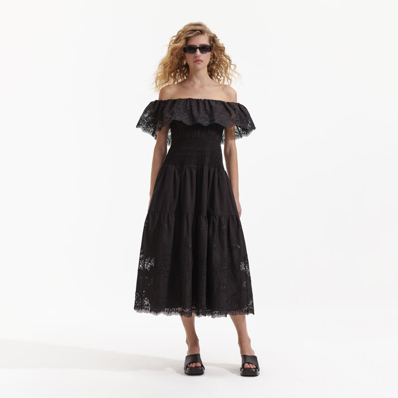 Model shot of black off the shoulder dress with floral lace inserts