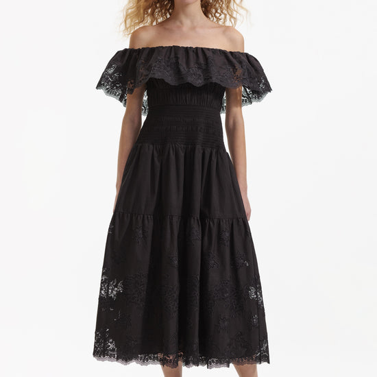 Model shot of black off the shoulder dress with floral lace inserts