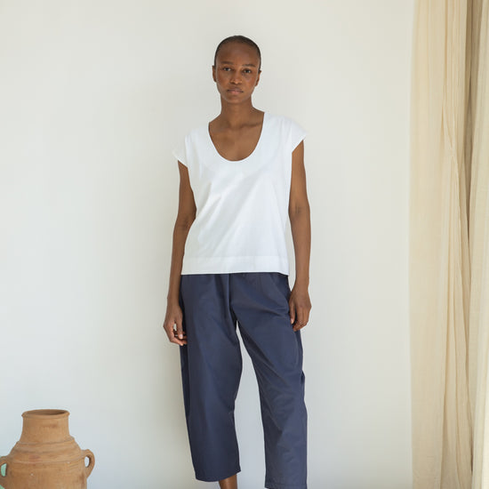 White organic cotton top worn with blue trousers 