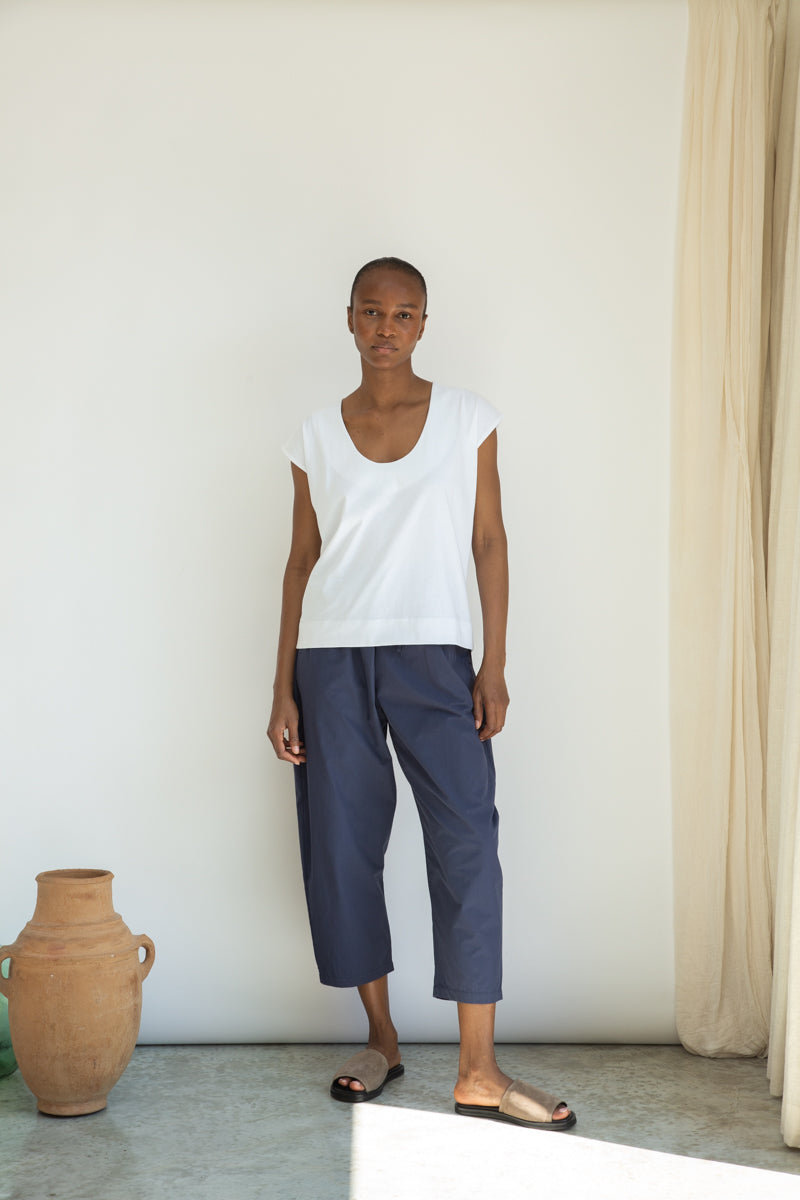 White organic cotton top worn with blue trousers 
