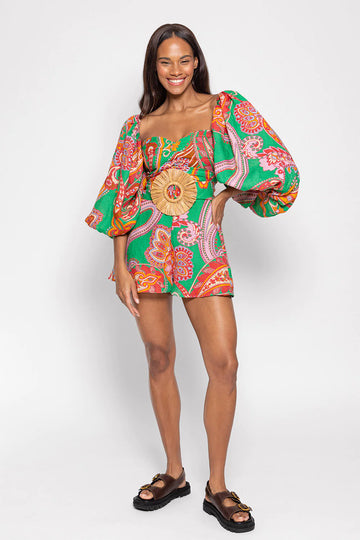 Green red and pink paisley print playsuit with oversized puff sleeves and a circle raffia belt