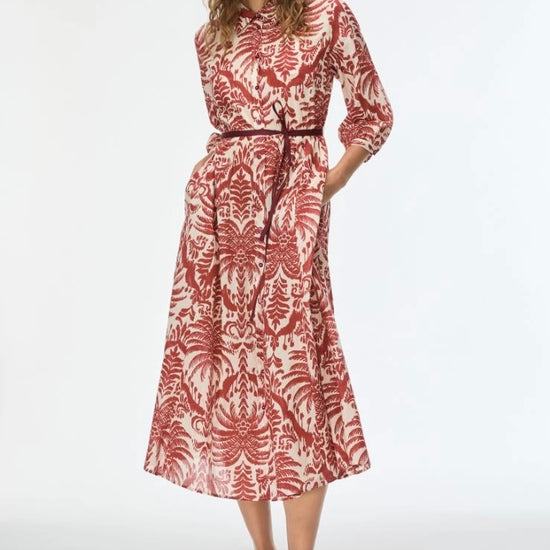 Woman wearing a red and white patterned dress on a white background