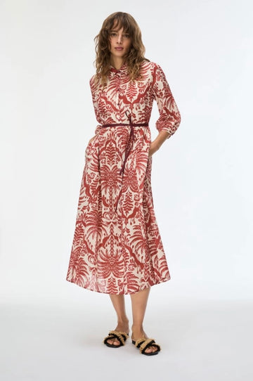 Woman wearing a red and white patterned dress on a white background