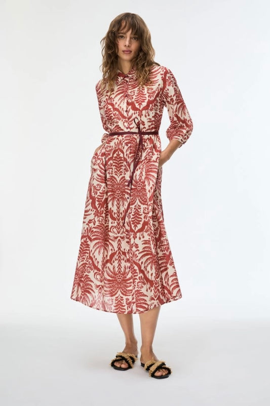 Woman wearing a red and white patterned dress on a white background