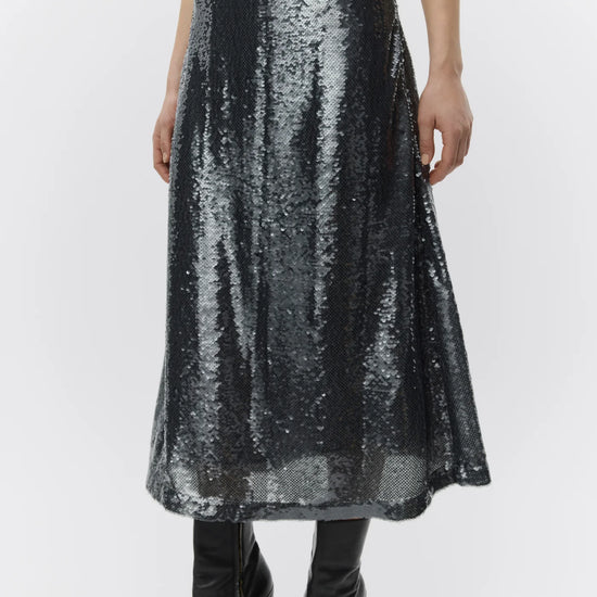 Person wearing a black sequin skirt on a white background