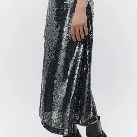 Silver sequin skirt worn by a person on a white background