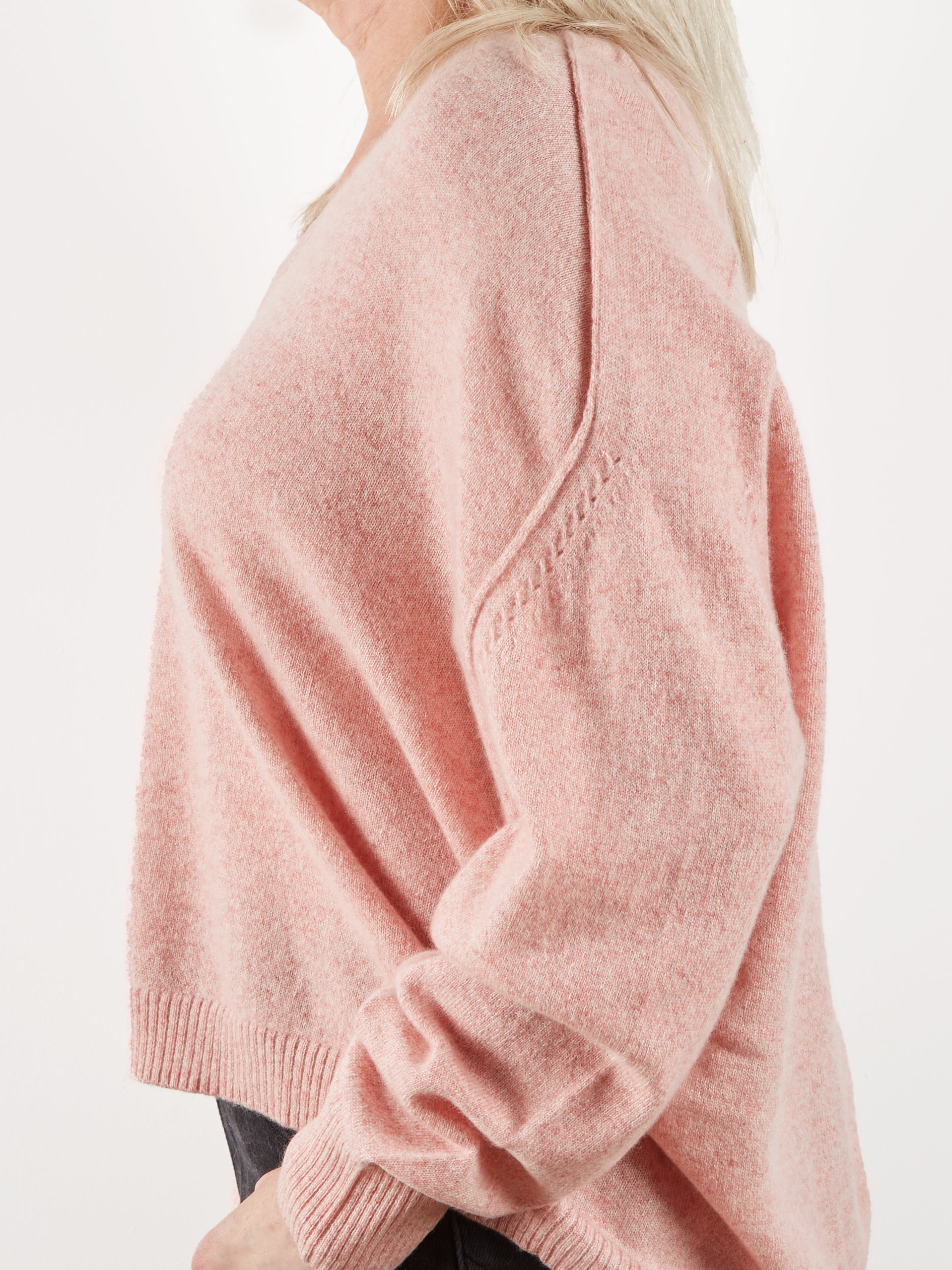 Side view of pink cashmere knit to show detail at the shoulder