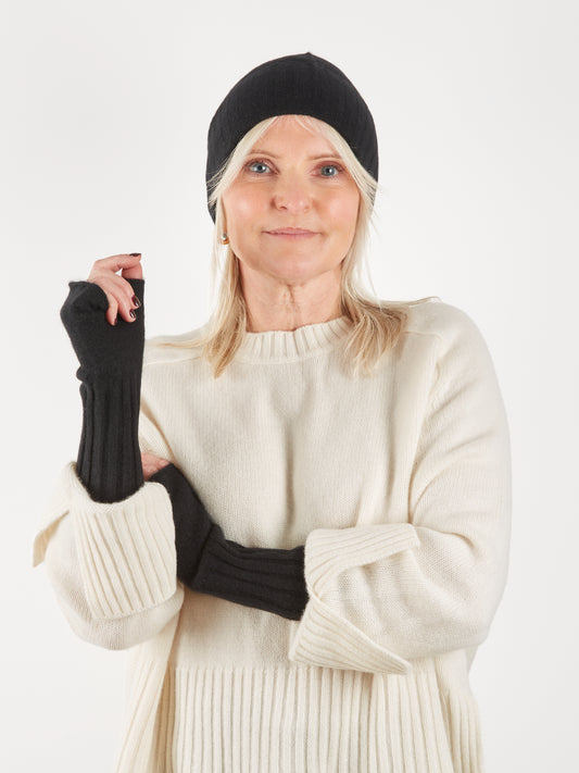 Black cashmere wrist warmers worn with matching beanie hat