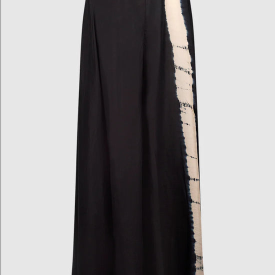 Wide leg black silk trousers with a tie dye feature leg and an elasticated waistband