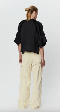 Crew neck semi sheer top with short wide raglan sleeves and tassel details throughout