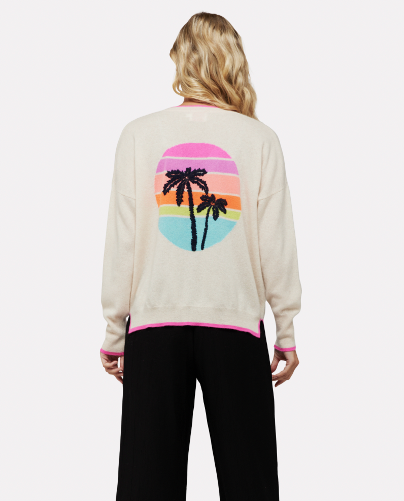Antique white V neck jumper with pink trim and vibrant sunset design on back with embroidered navy palm tree relaxed fit