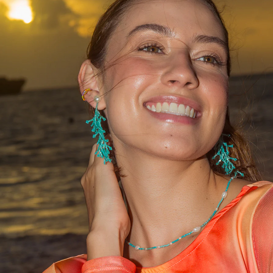 model shot of Coral shaped drop earrings in turquoise coloured beads hanging from a pearl stud