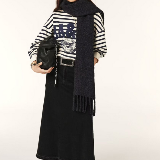 Navy and white striped sweatshirt with a blue decal on the front worn with skirt