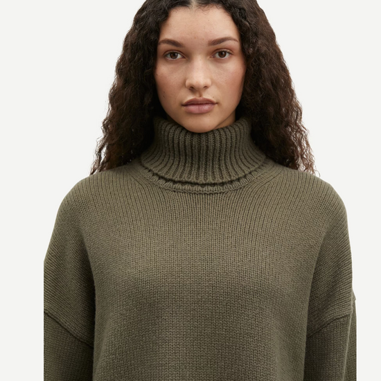 dark green turtle neck ribbed jumper with dropped shoulders close up