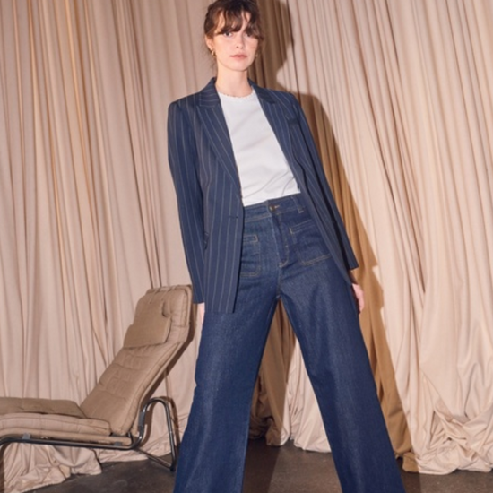 Model shot of navy pinstripe blazer worn with jeans