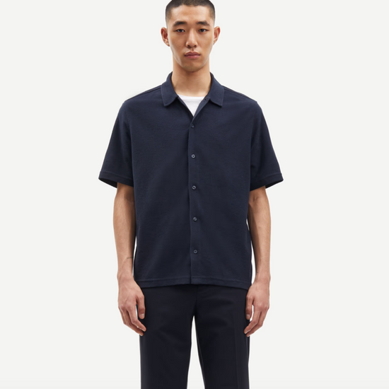 Navy button through polo shirt on model