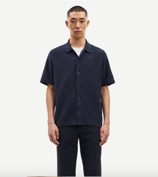 Navy button through polo shirt on model