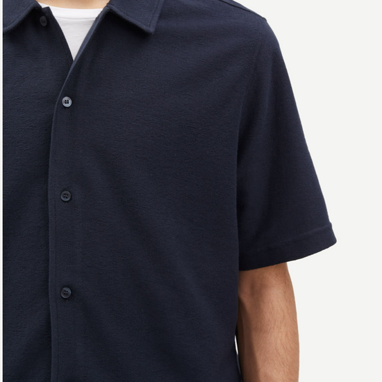 Close up of navy button through polo shirt