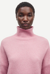 pink turtleneck jumper with ribbed neck, cuffs and hem model shot