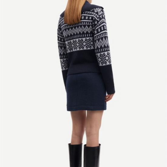 Rear view of navy and grey jaquard cardigan worn with mini skirt