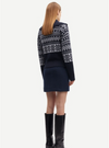 Rear view of navy and grey jaquard cardigan worn with mini skirt