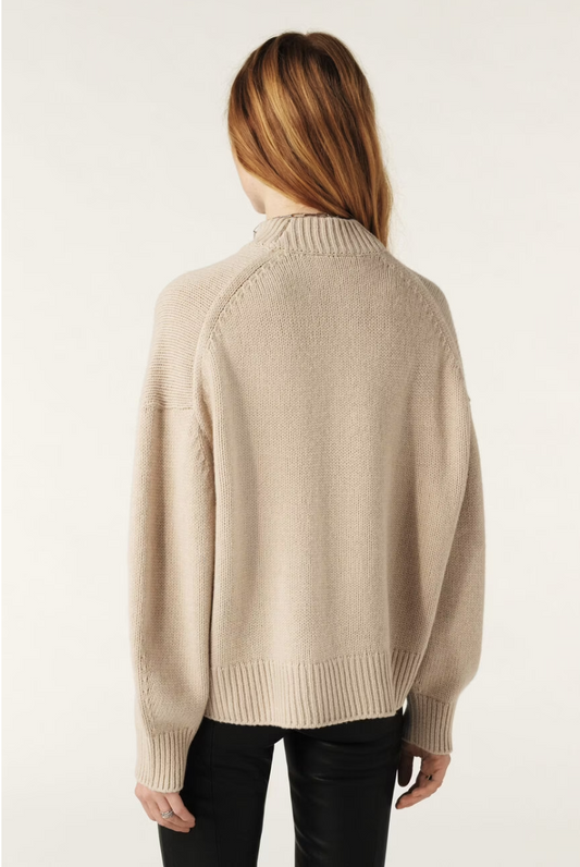 Rear view of beige turtle neck knit on model