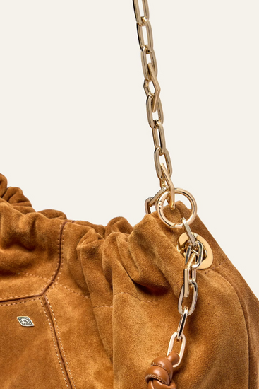 tan suede bag with scrunched top and gold chain strap close up