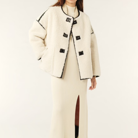 ecru faux fur shearling short jacket with brown leather piping, side pockets model shot