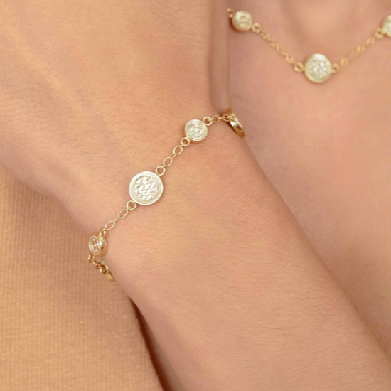 Gold bracelet with circular charms with dotting on model