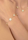 Gold bracelet with circular charms with dotting on model