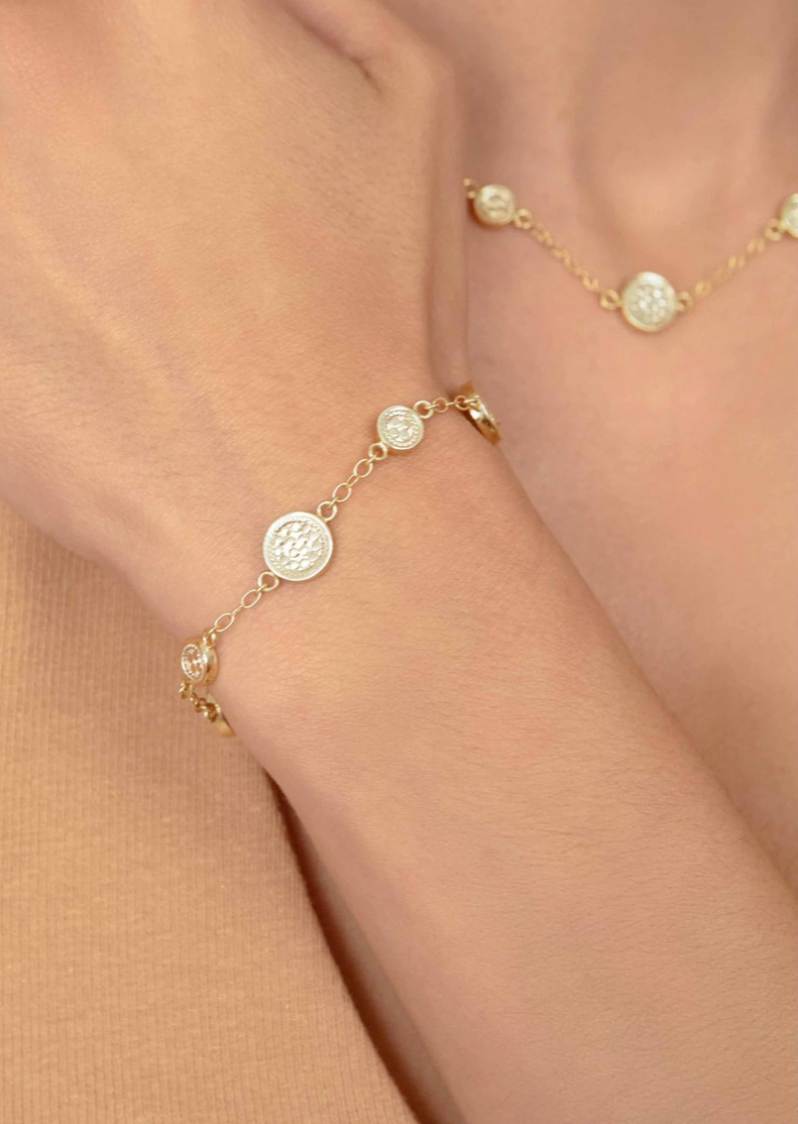 Gold bracelet with circular charms with dotting on model