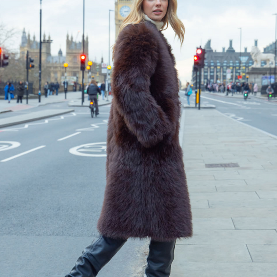 Woman in a fur coat walking on a city street with Big Ben in the background