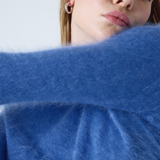 denim blue crew neck cashmere jumper with long sleeves and hairy textured feeling close up