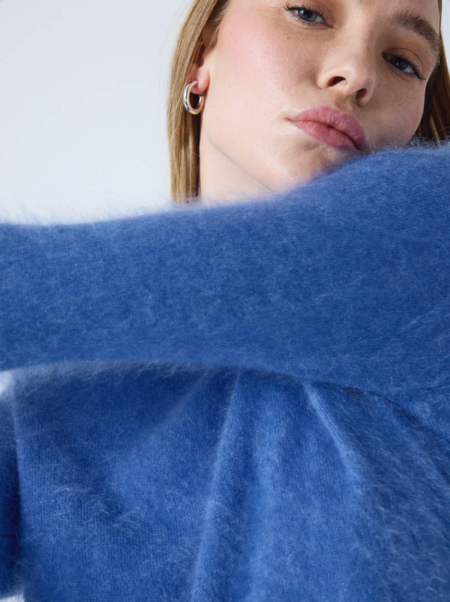 denim blue crew neck cashmere jumper with long sleeves and hairy textured feeling close up