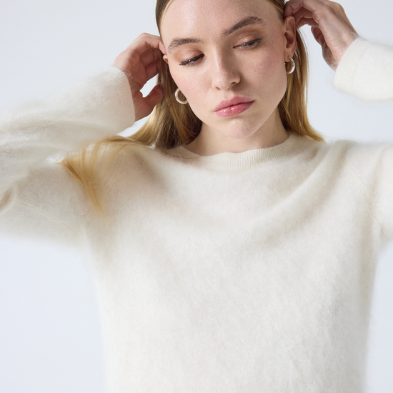 cream crew neck jumper with long sleeves and fluffy texture close up