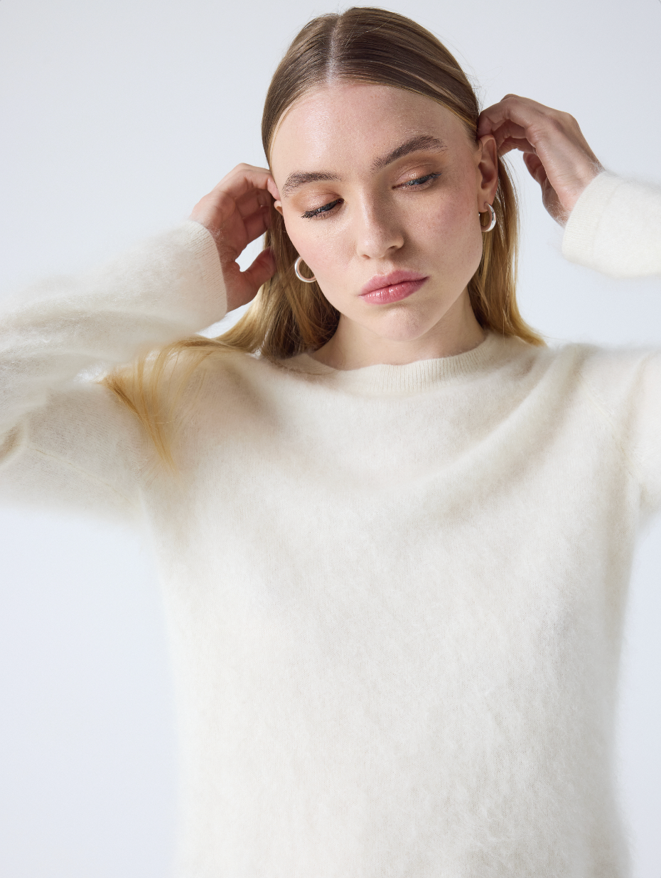 cream crew neck jumper with long sleeves and fluffy texture close up