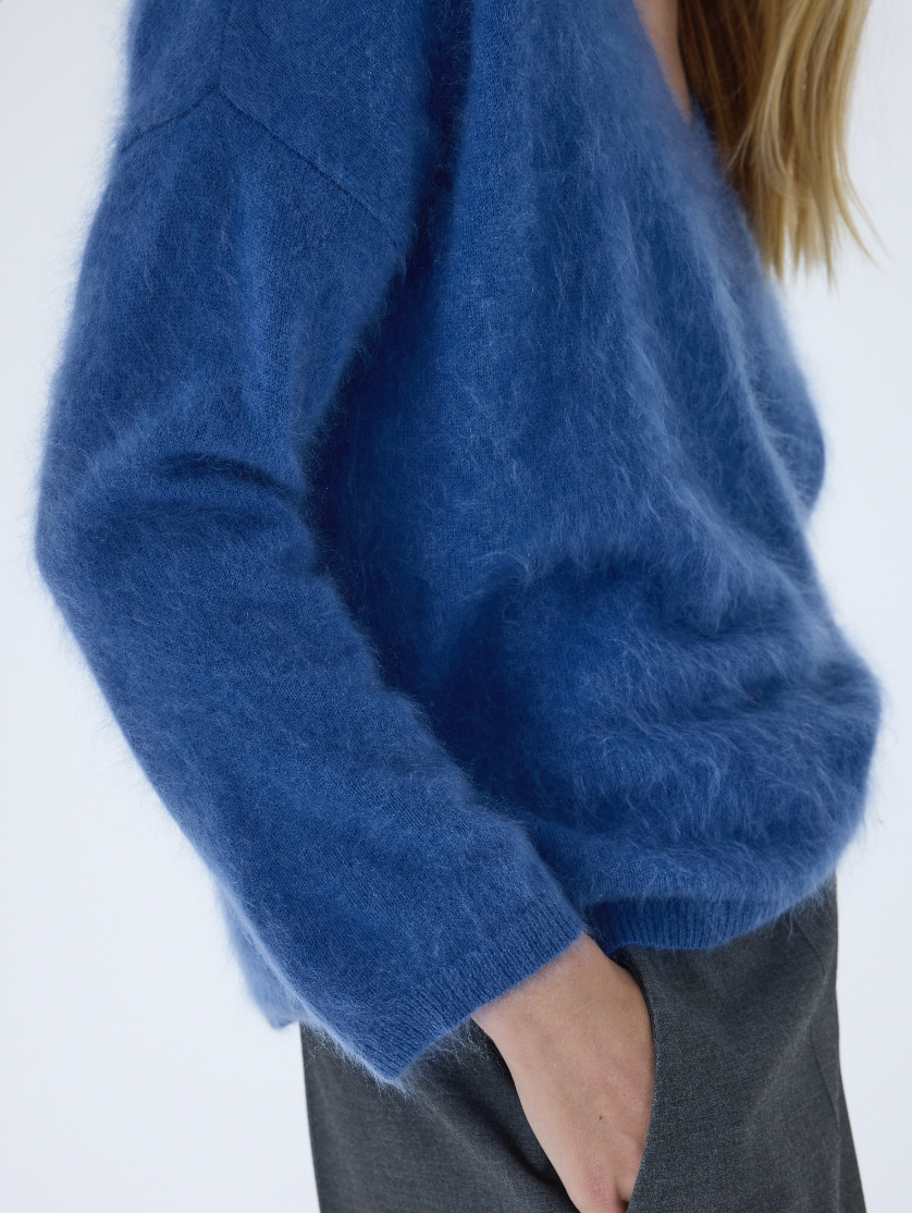 blue v neck jumper with long sleeves and fluffy texture close up