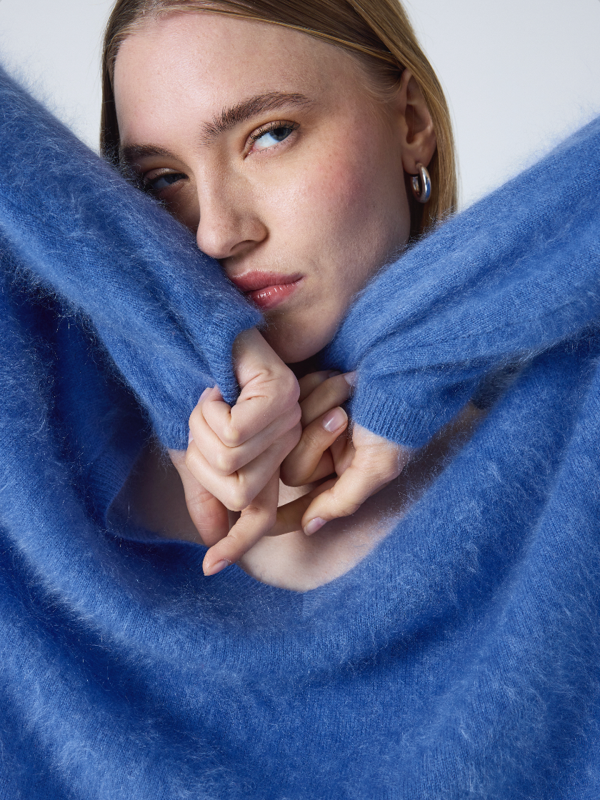 blue v neck jumper with long sleeves and fluffy texture close up